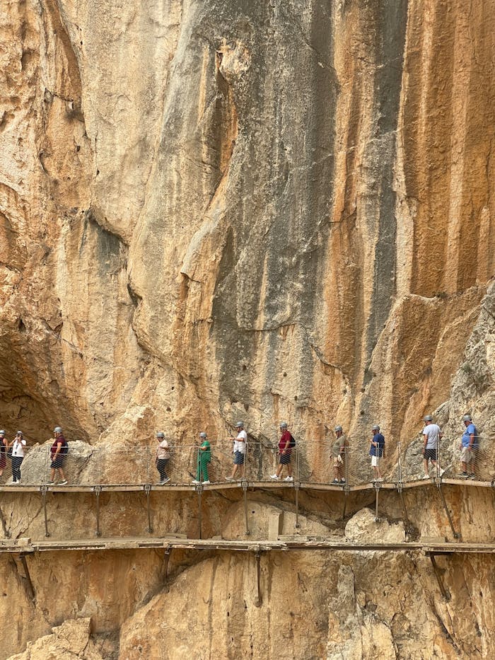 Visitors traverse the famous Caminito del Rey walkway in Málaga, Spain, offering striking views.