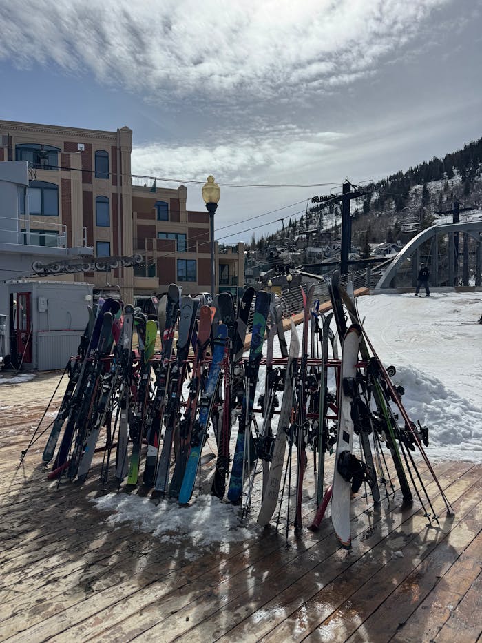 Vibrant skis stand ready by a snowy slope in Park City, Utah, under a bright winter sky.
