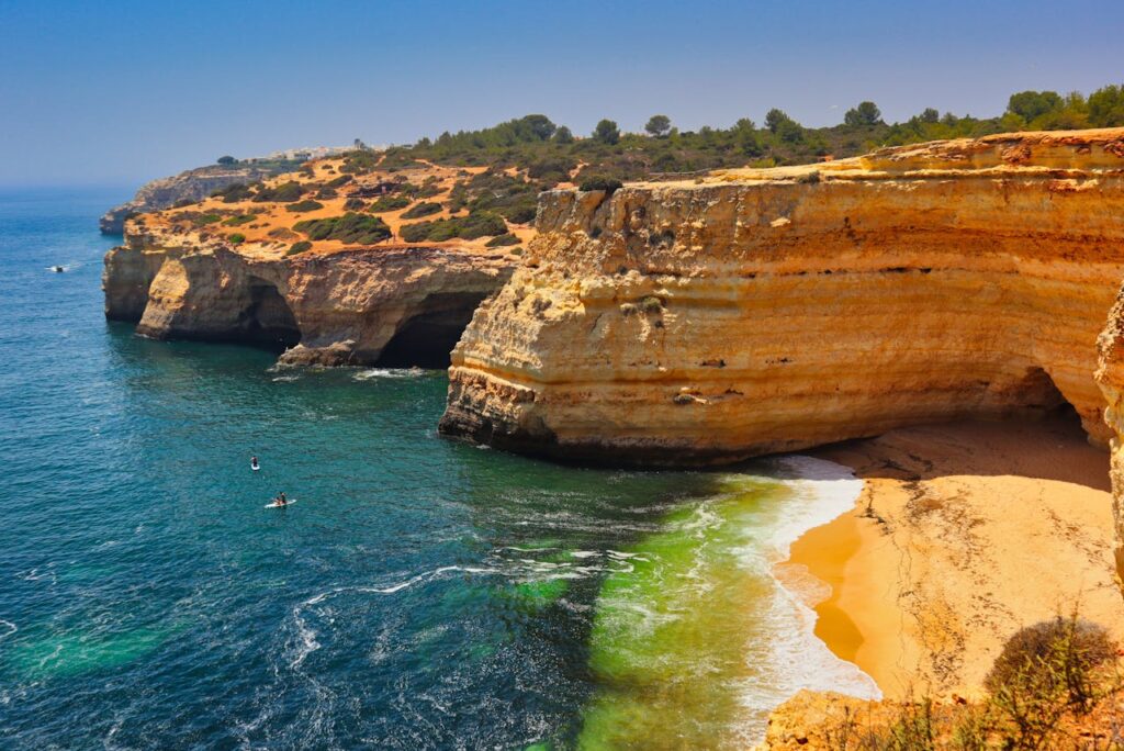 A breathtaking aerial view of Algarve cliffs and turquoise waters in Portugal's Praia de Corredoura.