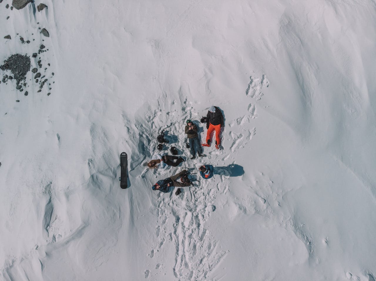Drone shot capturing a group relaxing on a snowy slope in Les Belleville, France.